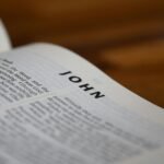 Detailed close-up of the Bible open to the Gospel of John with blurred background.
